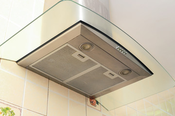 Metal cooker hood extractor fan with spotlight in luxury kitchen.