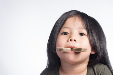 Portraits a Little Cute Thailand Girl and wafer in the mouth.