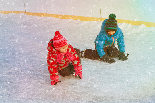 little boy and girl learning to skate, kids winter sport