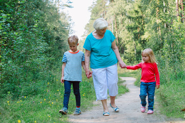 Fototapeta premium happy senior grandmother with kids walk in nature