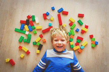 happy little boy love playing with plastic blocks