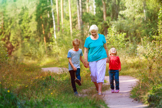 happy senior grandmother with kids walk in nature