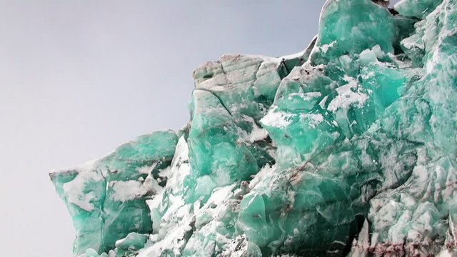 Turquoise color glacier on background of snow in Arctic. Amazing ice desert landscape. Silence quiet of wilderness North Pole Way to Pyramid on Spitsbergen Svalbard in Norway.