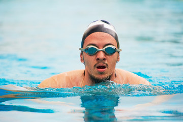 Fototapeta na wymiar Man in goggles swimming in pool
