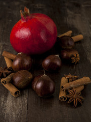Chestnut and Pomegranate  together cinnamon and star anise on a wooden background