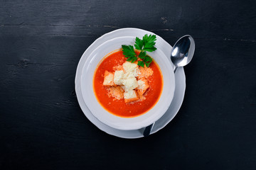 Tomato soup. On a wooden surface. Top view. Free space for your text.