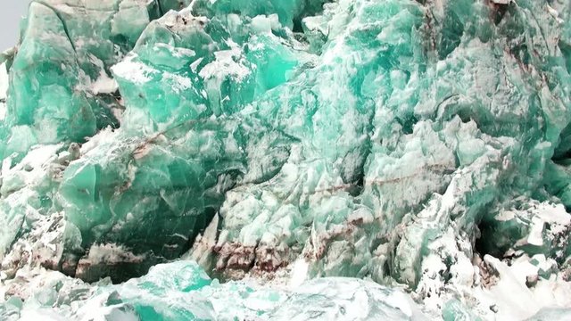Glacier of beautiful unique turquoise color on background of snow in Arctic. Amazing ice desert landscape. Silence quiet of wilderness North Pole Way to Pyramid on Spitsbergen Svalbard in Norway.