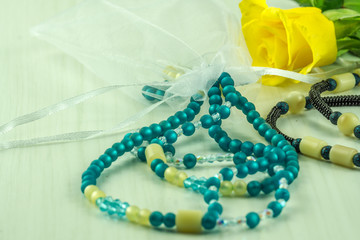 Necklace of pearls with a white bow and a yellow rose
