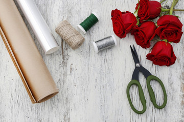 Paper or plastic stretch film as wrapping for red rose flowers.