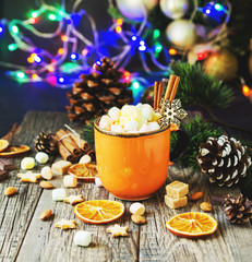 a cup of Christmas hot cocoa with marshmallow New Year's lights and decorations, selective focus