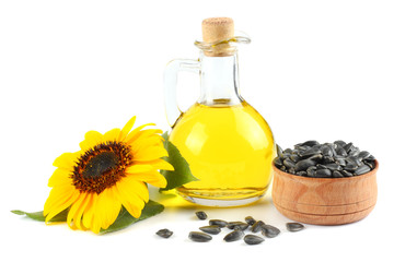 Sunflower oil in glass jug, seeds and flower isolated on white background