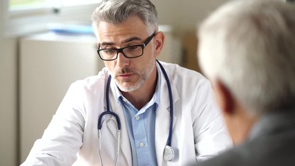 Doctor talking to patient in office - Powered by Adobe