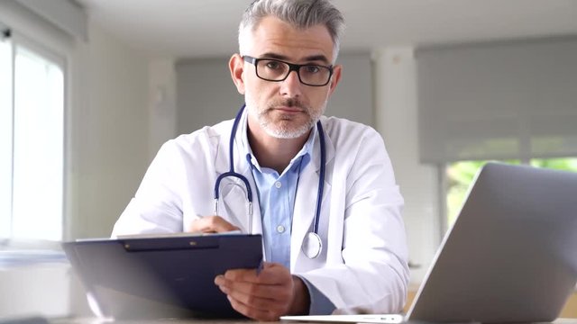 Doctor in office working on patient file