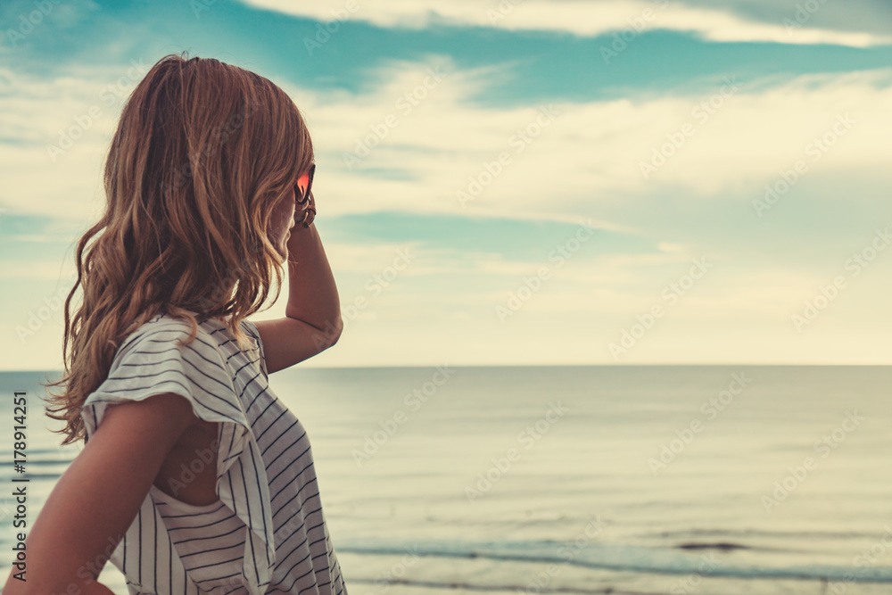 Wall mural girl enjoying the ocean tropical view scenery.