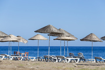 Fototapeta na wymiar Sunbeds and umbrella on the beach, close up. Turkey