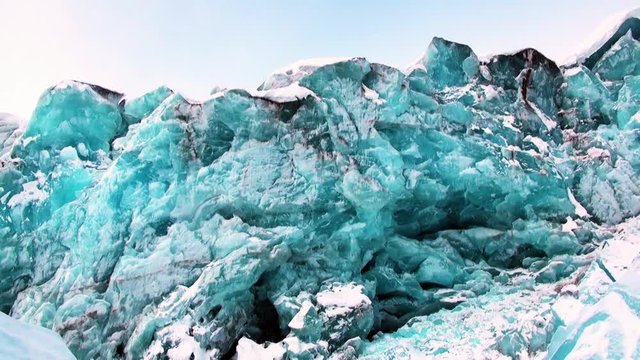 Glacier of beautiful unique turquoise color on background of snow in Arctic. Amazing ice desert landscape. Silence quiet of wilderness North Pole Way to Pyramid on Spitsbergen Svalbard in Norway.