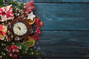 Clock. Christmas wooden background. New Year's holiday. Christmas motive. On a wooden surface. Top view. Free space for your text.