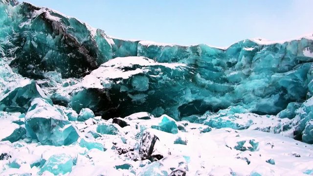 Glacier of beautiful unique turquoise color on background of snow in Arctic. Amazing ice desert landscape. Silence quiet of wilderness North Pole Way to Pyramid on Spitsbergen Svalbard in Norway.