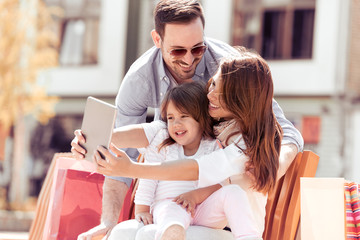 Parents with his daughter taking selfie outdoors.