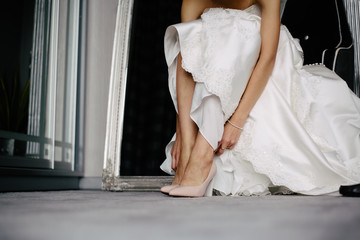 Obraz na płótnie Canvas the bride is putting on shoes