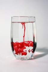 Red color drop in a octagon glass of water. abstract of color dancing in the water.