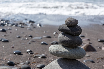 Fototapeta na wymiar Stack of dark stones on the beach