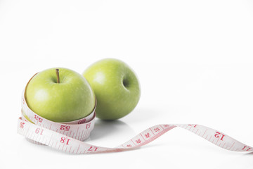 green apple with measure tape on white background. concept nutrition healthy.