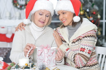 senior woman and young woman with gift