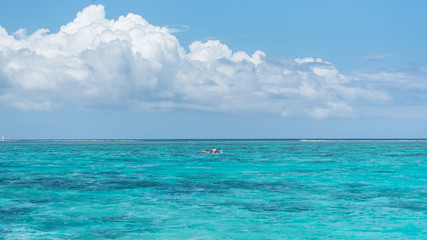 Fototapeta premium Panorama of the lagoon and the coral reef in background in Tahiti, with a kayak on the lagoon 