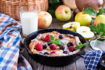 Cinnamon Apple Dutch Baby Pancake in iron pan. Style rustic. Selective focus