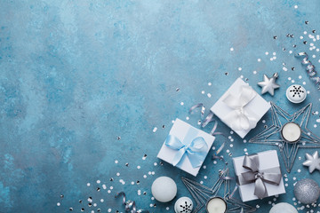 Fashion christmas background. Gift boxes and holiday decoration on blue vintage table top view. Flat lay. Greeting card with copy space for text.