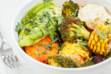 salad with baked vegetables, hummus and avocado