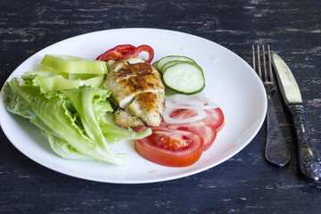 A fresh meal of chicken fillet with vegetables and tasty juice on a dark wooden background