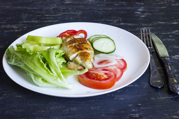 A fresh meal of chicken fillet with vegetables and tasty juice on a dark wooden background