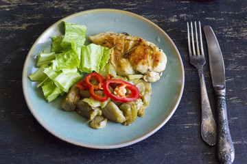 A fresh meal of chicken fillet with vegetables and tasty juice on a dark wooden background