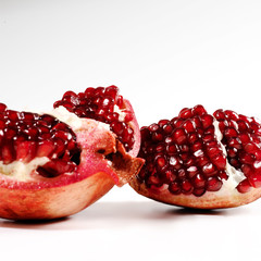 Two pomegrantes on a white  background.