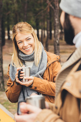 couple with hot drinks on nature