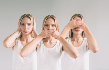 Isolated studio shot of a Caucasian woman in the See No Evil, Hear No Evil, Speak No Evil poses.