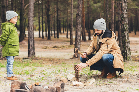 Father And Son Cutting Wood For Bonfire