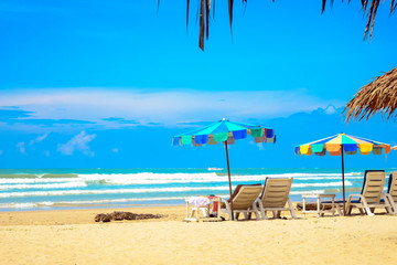Obraz na płótnie Canvas Beautiful sand beach and colorful umbrella with chair, tropical sea ocean
