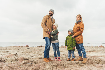 family embracing on sandy beach