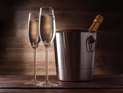 Photo of two wine glasses with champagne, steel bucket