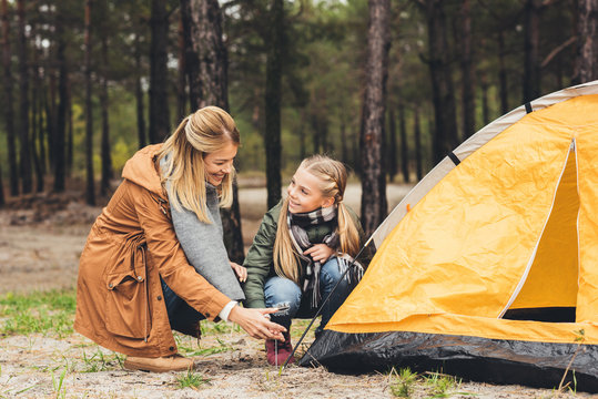 mother and daughter installing camping tent - Powered by Adobe