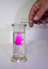 Two clear liquids, one alkaline, one phenolphtalein, are mixed and become purple red.