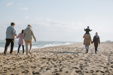 multigenerational family walking on seashore