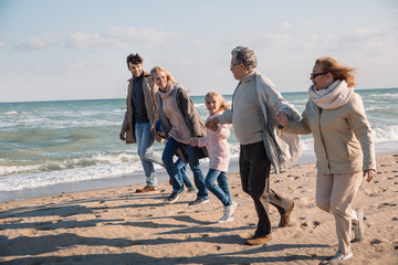 multigenerational family running on beach