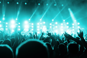 Concert Crowd. Silhouettes young people in front of bright stage lights. Band of rock stars