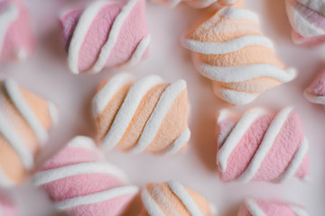 Marshmallows on pink background . Flat lay or top view. Background or texture of colorful mini marshmallows. Winter food background concept.