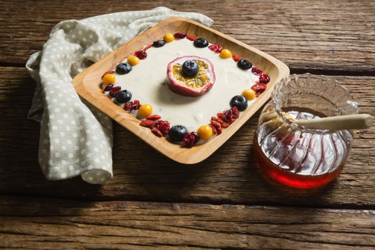 Fruit yogurt and honey on a wooden table