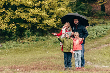 family with umbrella in park